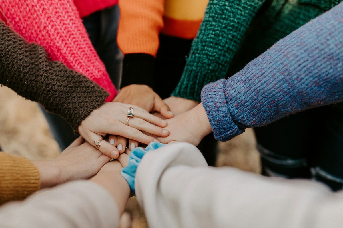 Many hands stacked together in shared commitment